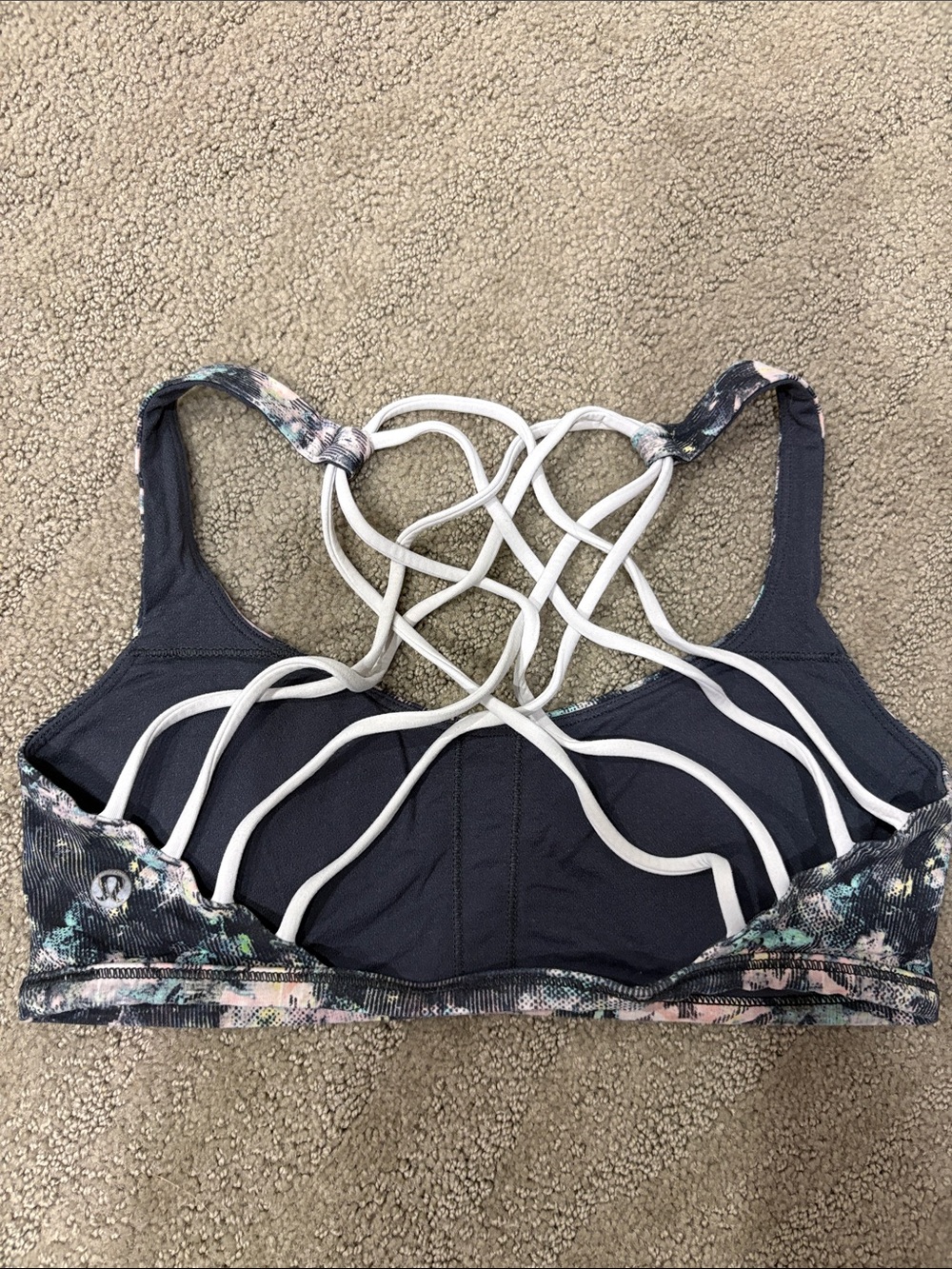 lululemon athletica dark gray sports bra with white strappy back and floral band